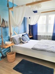 a bedroom with a bed with a canopy over the water at Wera - klimatyczny apartament 300 m od plaży Brzeźno - AZW Gdańsk in Gdańsk