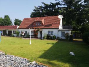 a small white house with a antenna on top of a yard at FEWO Vermietung Carmen Sagner in Baabe