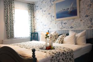 a bedroom with a bed with a table with flowers on it at FEWO Vermietung Carmen Sagner in Baabe