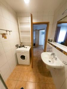 a bathroom with a washing machine and a sink at FEWO Vermietung Carmen Sagner in Baabe +36 photos