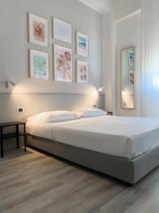 a bedroom with a large bed and some pictures on the wall at Il Romito in Quercianella