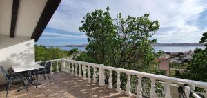 een balkon met een tafel en stoelen en uitzicht op het water bij Apartman Marija in Cesarica