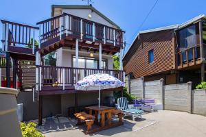 a house with an umbrella and a table and chairs at Paradise View in Knysna
