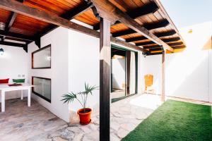 a living room with a wooden ceiling and green grass at Casa Higuereta II in Corralejo