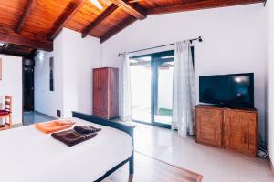 Schlafzimmer mit einem Bett, einem TV und einem Fenster in der Unterkunft Casa Higuereta II in Corralejo