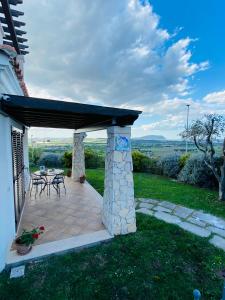 eine Terrasse mit einem Dach, einem Tisch und Stühlen in der Unterkunft CASA VACANZA FELICITA' in Porto Potenza Picena