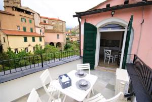 a balcony with a table and chairs on a building at Casa di Luigi ed Ernestina in Dolcedo