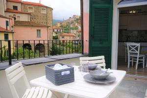 d'une table et de chaises blanches sur un balcon. dans l'établissement Casa di Luigi ed Ernestina, à Dolcedo