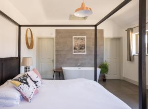 a bedroom with a bed and a bath tub at Clopton Courtyard Cambridge in Cambridge