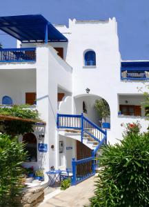 un edificio blanco con escaleras y plantas azules en fi naxos en Agios Prokopios