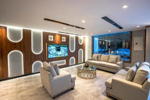 a living room with two couches and a tv at Verdun Suites in Medina