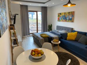 Milmari Resort - Apartman L43 في كوباونيك: غرفة معيشة مع أريكة زرقاء وطاولة