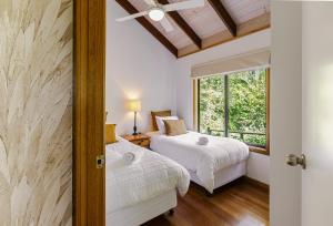 a bedroom with a bed and a window at Lake Weyba Cottages Noosa in Peregian Beach