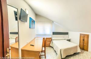 サンシェンショにあるApartamento Mardevelaのベッドルーム(ベッド1台、デスク、鏡付)