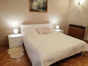a bedroom with a white bed and two night stands at Lovely apartment in Pomer in Pomer