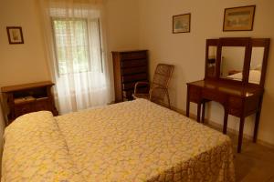 a bedroom with a bed and a desk and a mirror at PODERE 31 in Santa Margherita di Pula