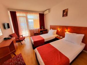a hotel room with two beds and a chair at Hotel Tomis Neptun in Neptun +43 photos