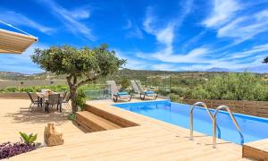 Villa Canes Heated Pool في Vathi: حديقة خلفية بها مسبح وطاولة وكراسي