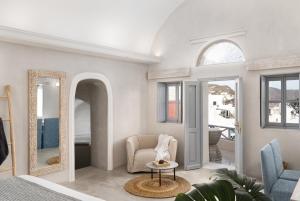 - un salon avec une chaise et un miroir dans l'établissement Bubble Suite Santorini, à Oia