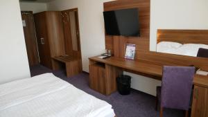 a hotel room with two beds and a television at Hotel Saffron in Bratislava