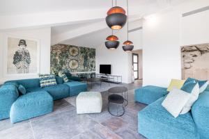 a living room with blue couches and a table at Les Terrasses de Fromentica in Saint-Florent