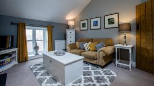 a living room with a couch and a table at Broadrock Accommodation - Clock Cottage in Chepstow