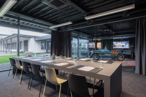 a long table and chairs in a room at V8 Hotel Köln at MOTORWORLD in Cologne