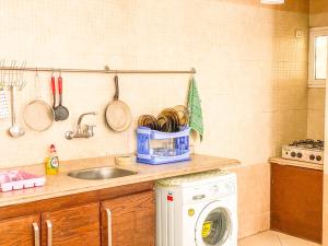 cocina con fregadero y lavadora en The Touristic Promenade Apartment en Hurghada