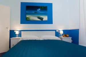 una camera blu con un letto e due comodini di Il Mandarino Rooms & Apartments a Cittadella del Capo