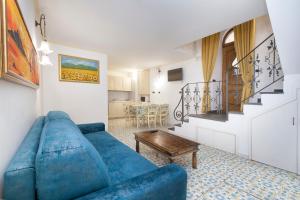 ein Wohnzimmer mit einem blauen Sofa und einem Tisch in der Unterkunft Casa Vilù in Sorrent
