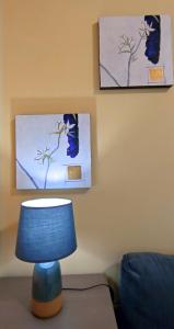 
a blue vase sitting on top of a wall next to a picture at Apartment Alacas Sevilla in Seville
