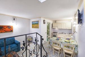 una cucina e una sala da pranzo con tavolo e sedie di Casa Vilù a Sorrento