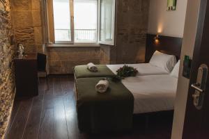 A bed or beds in a room at Pensión A Casa do Peregrino