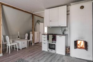 uma cozinha com armários brancos e um fogão com lareira em Newly renovated apartment in a woodenhouse from 1910 in Martti! em Turku
