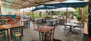 a restaurant with tables and chairs and umbrellas at Bella Napoli Guesthouse Trattoria Pizzeria in La Spezia