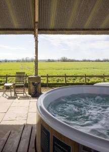 uma banheira de hidromassagem num pátio com vista para um campo em Clopton Courtyard Cambridge em Cambridge