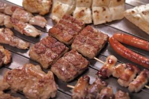 uma grelha com carne e cachorros-quentes em Apartment Nemanja em Banja Luka