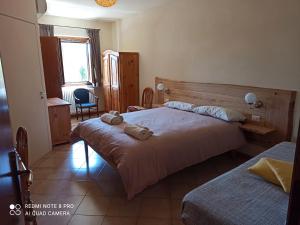 a hotel room with two beds and a window at Trattoria della Posta in Peveragno