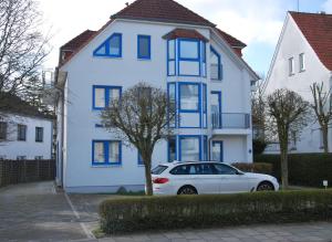 un coche blanco estacionado frente a una casa blanca en Seemöwe Whg. 8 en Cuxhaven