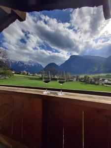- deux verres à vin sur un livre avec vue sur les montagnes dans l'établissement Landhaus Zillertal, à Ramsau im Zillertal