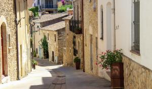 an alley in an old town with flowers at Alta House Begur in Begur