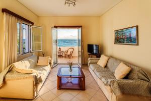 a living room with two couches and a table at On the Beach - Akroyali Family Lodging in Akrogiali