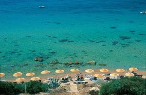uma praia com guarda-sóis e cadeiras e o oceano em iGV Club Vacanze Le Castella em Le Castella