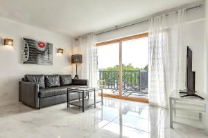 a living room with a couch and a large window at Modern apartment in Parque Royal I, Playa Fañabe in Adeje
