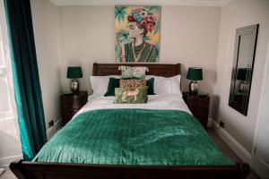 a bedroom with a bed with a green comforter at Slate Hall in Seahouses