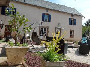 un giardino di fronte a una casa con tubo di La Douce Parenthèse B&B entre bois et champs-Accueil motards a Montirat