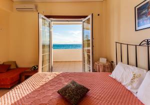 1 dormitorio con cama y vistas al océano en On the Beach - Akroyali Family Home, en Akrogiali