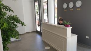 a little girl sitting at a counter in a building at Joel Residence in Durrës
