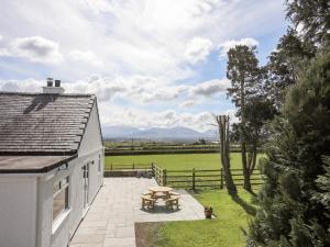 een wit huis met een patio en een tafel bij Mynydd Mwyn in Llanfairpwllgwyngyll