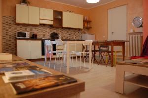 a kitchen with white cabinets and a table and chairs at Corte Colori in Colà di Lazise